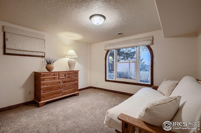 bedroom with carpet floors, a textured ceiling, baseboards, and visible vents
