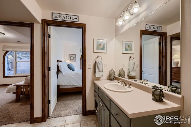 bathroom featuring vanity, tile patterned flooring, baseboards, and ensuite bath