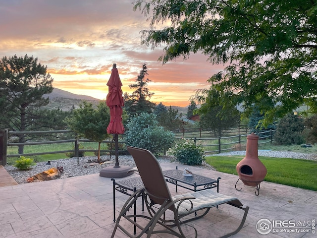 view of patio with fence and a mountain view