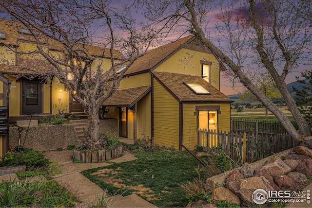 view of front of home featuring fence and a shingled roof