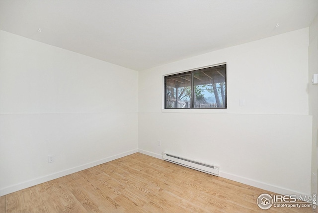 unfurnished room featuring baseboards, wood finished floors, and baseboard heating