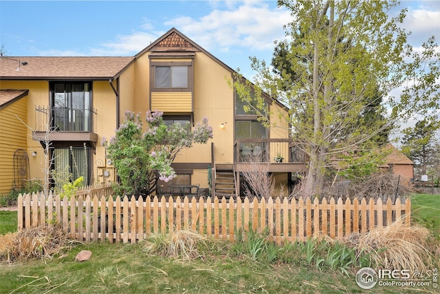 view of front facade featuring stairway and fence private yard