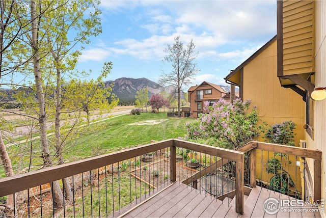 wooden terrace with a lawn and a mountain view
