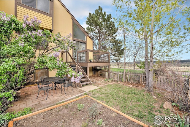view of yard featuring a deck, a fenced backyard, a patio area, and stairs