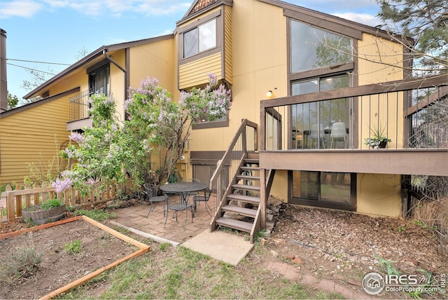 rear view of house featuring fence, stairs, a patio area, and a wooden deck
