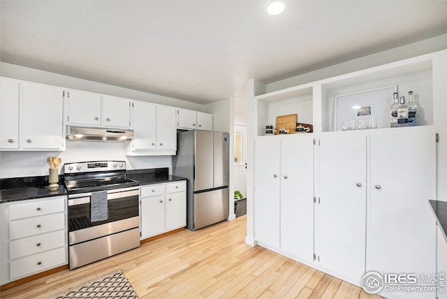 kitchen with dark countertops, appliances with stainless steel finishes, light wood-type flooring, white cabinets, and under cabinet range hood