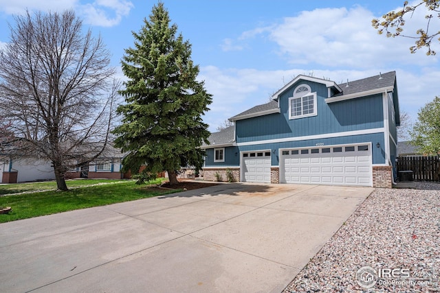 view of front of property with brick siding, fence, a front lawn, concrete driveway, and an attached garage