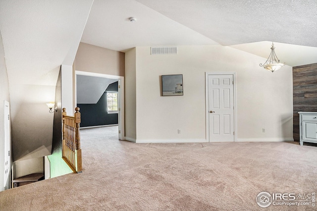 unfurnished living room with baseboards, visible vents, and carpet