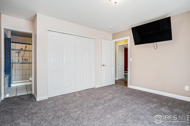 unfurnished bedroom featuring carpet flooring, baseboards, ensuite bathroom, and a closet