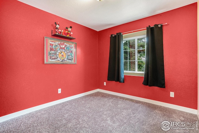 unfurnished room featuring baseboards and carpet