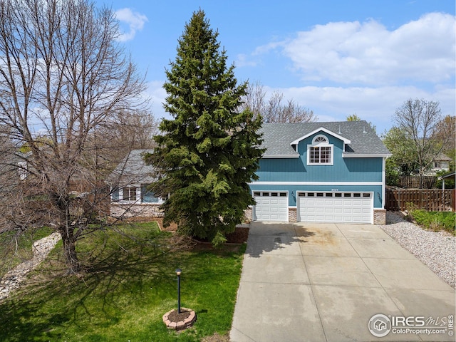 view of front of home featuring a garage, fence, stone siding, a shingled roof, and driveway