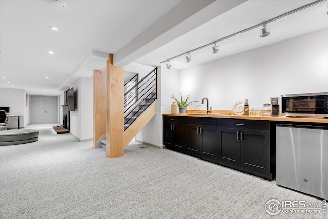 bar featuring fridge, a sink, stainless steel microwave, light carpet, and stairs