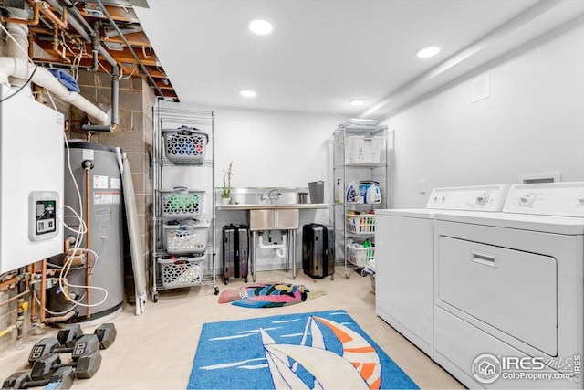 basement with visible vents, washing machine and clothes dryer, concrete block wall, water heater, and recessed lighting