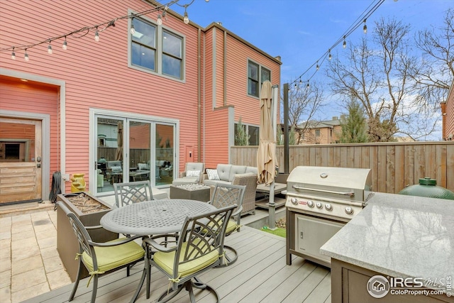 deck featuring an outdoor living space, fence, outdoor dining area, and a grill