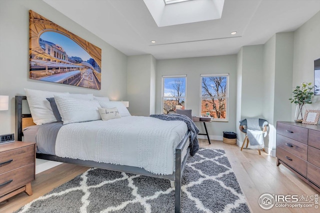 bedroom featuring a skylight, recessed lighting, and light wood-style flooring