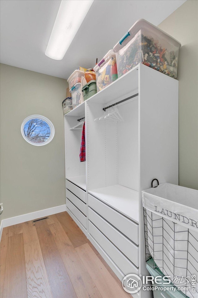 walk in closet featuring light wood-type flooring and visible vents