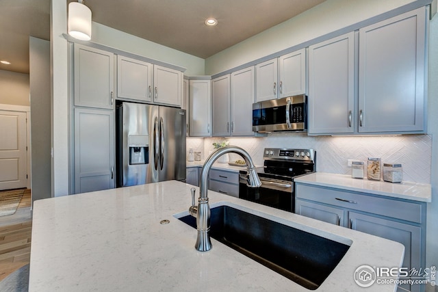 208 High Point Dr, Longmont, CO 80504 - kitchen with a sink, appliances with stainless steel finishes, decorative backsplash, and light stone countertops