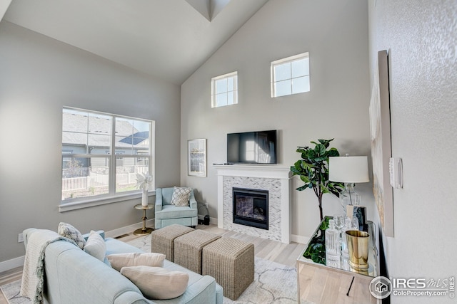208 High Point Dr, Longmont, CO 80504 - living room featuring high vaulted ceiling, baseboards, a tile fireplace, and wood finished floors