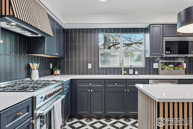kitchen featuring a sink, light countertops, stainless steel range with gas cooktop, decorative backsplash, and custom range hood