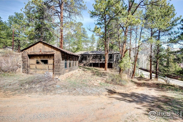 exterior space with dirt driveway and an outbuilding