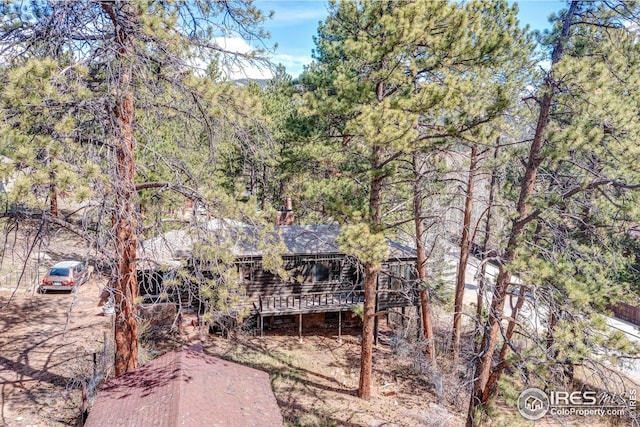 back of house featuring a deck and a forest view