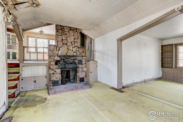 unfurnished living room featuring concrete flooring, vaulted ceiling, and a fireplace