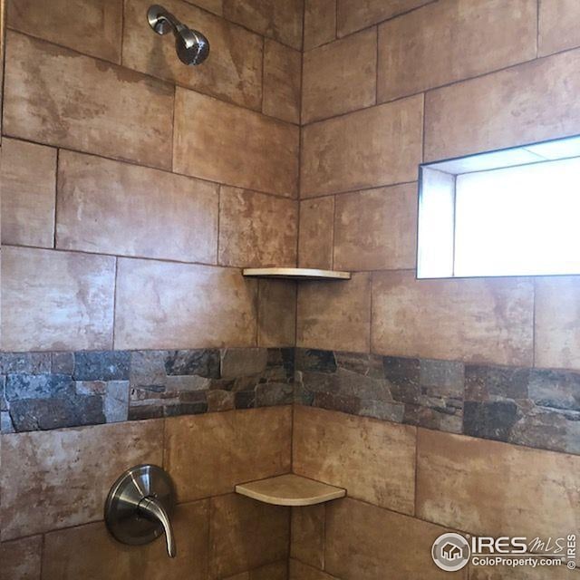 interior details featuring tiled shower