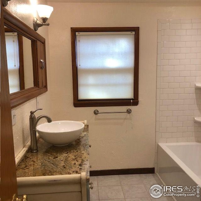 bathroom with tile patterned flooring, baseboards, and vanity