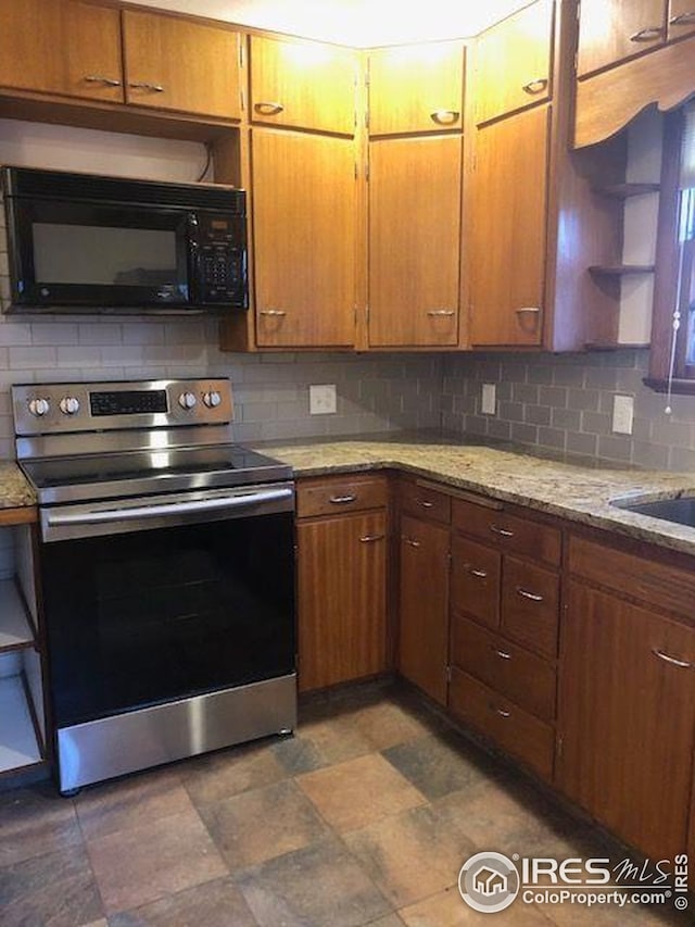 kitchen featuring open shelves, black microwave, light stone counters, stainless steel range with electric stovetop, and backsplash