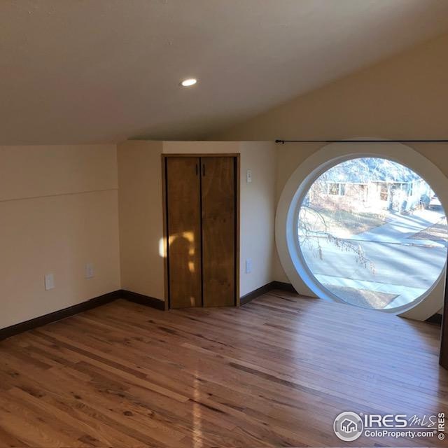 spare room featuring recessed lighting, baseboards, and wood finished floors