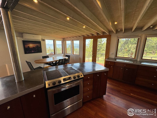 kitchen featuring electric range, beam ceiling, dark wood finished floors, stainless steel counters, and a wall unit AC