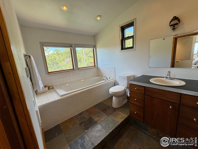 full bath featuring stone tile flooring, plenty of natural light, a garden tub, and toilet