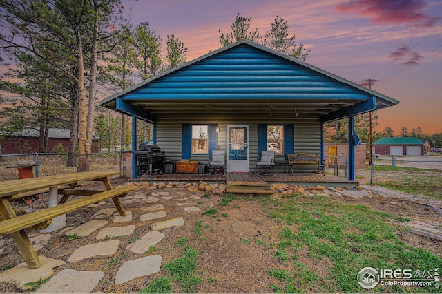 back of property featuring fence and a porch