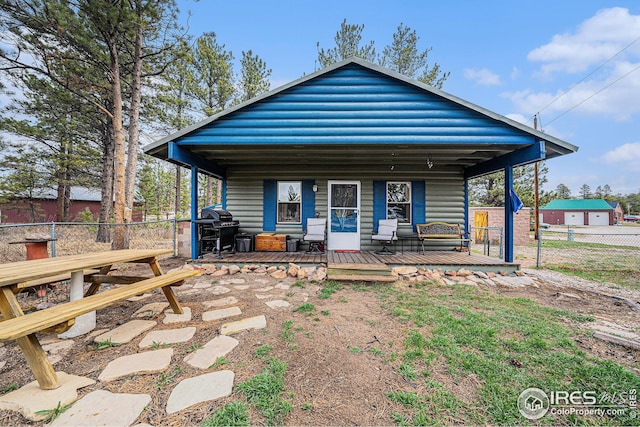 back of property with a porch and fence