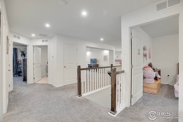 corridor featuring carpet flooring, recessed lighting, visible vents, and an upstairs landing