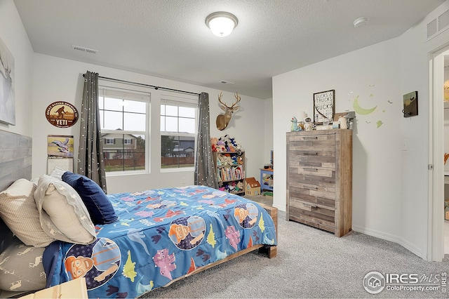 carpeted bedroom with a textured ceiling and visible vents