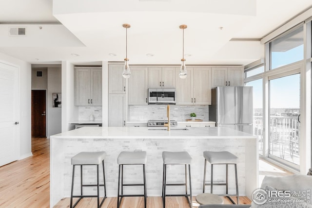 1700 Bassett St Unit 1808, Denver, CO 80202 - kitchen featuring a kitchen breakfast bar, stainless steel appliances, tasteful backsplash, and visible vents