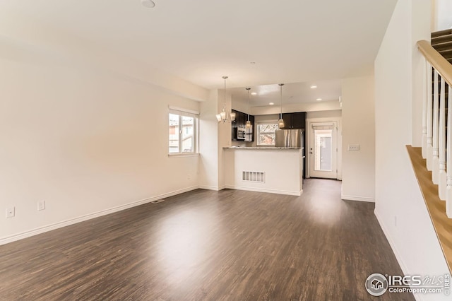 unfurnished living room with dark wood-style flooring, stairs, recessed lighting, baseboards, and visible vents