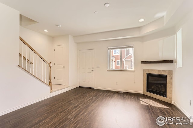 unfurnished living room featuring baseboards, recessed lighting, wood finished floors, and a tile fireplace