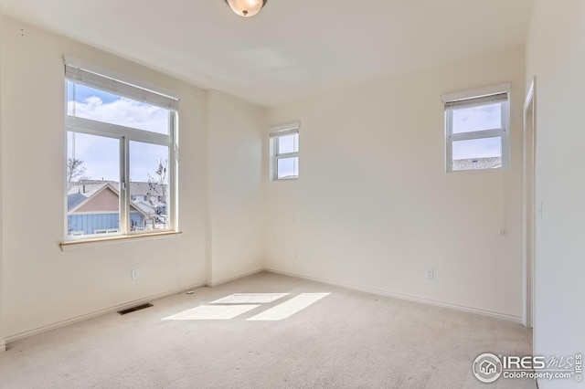 unfurnished room with baseboards, carpet, and visible vents