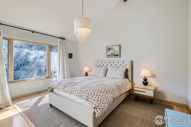 912 Sailors Reef Ft, Collins, CO 80525 - bedroom with visible vents, wood finished floors, baseboards, high vaulted ceiling, and a notable chandelier