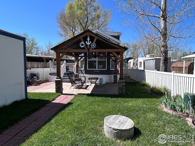 rear view of house featuring fence, a gazebo, a yard, and a patio area