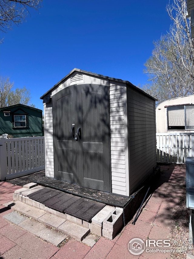 view of shed featuring fence