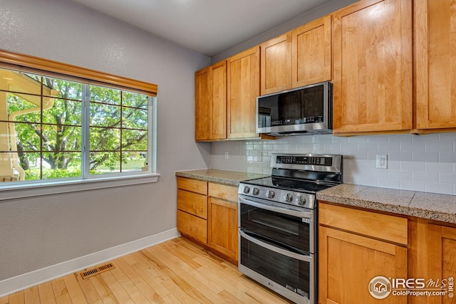kitchen with visible vents, baseboards, tile counters, tasteful backsplash, and stainless steel appliances
