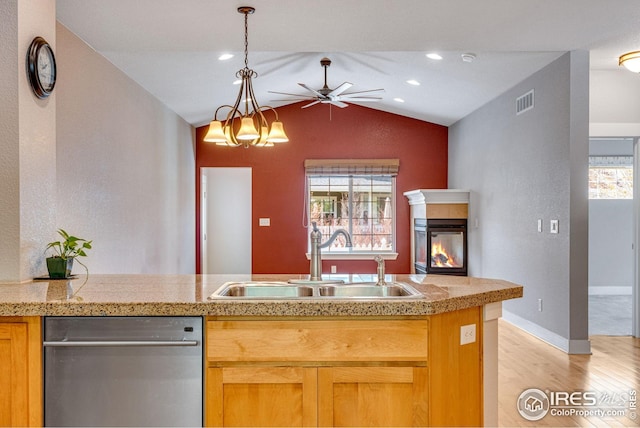 kitchen with ceiling fan, a sink, dishwasher, tile counters, and lofted ceiling