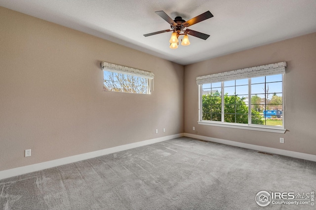 empty room with baseboards, carpet floors, and visible vents