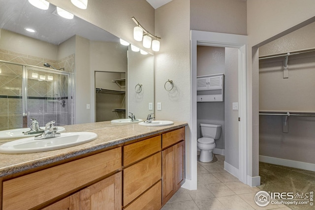 full bath with a sink, tile patterned floors, a shower stall, and toilet