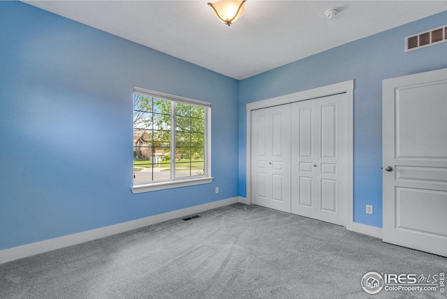 unfurnished bedroom featuring visible vents, carpet, and baseboards
