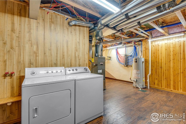 washroom with laundry area, wood walls, independent washer and dryer, and gas water heater
