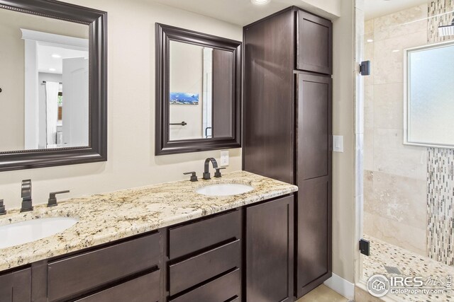 bathroom with double vanity, a shower stall, and a sink